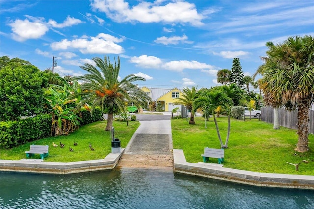 view of property's community with a water view and a yard