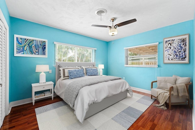 bedroom with dark hardwood / wood-style floors and ceiling fan