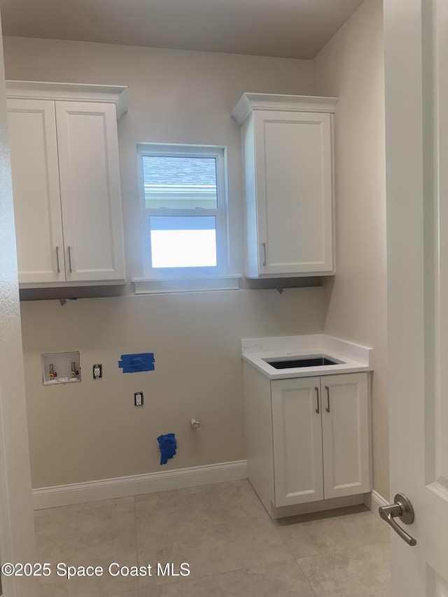 laundry room featuring washer hookup, hookup for a gas dryer, light tile patterned flooring, a sink, and baseboards