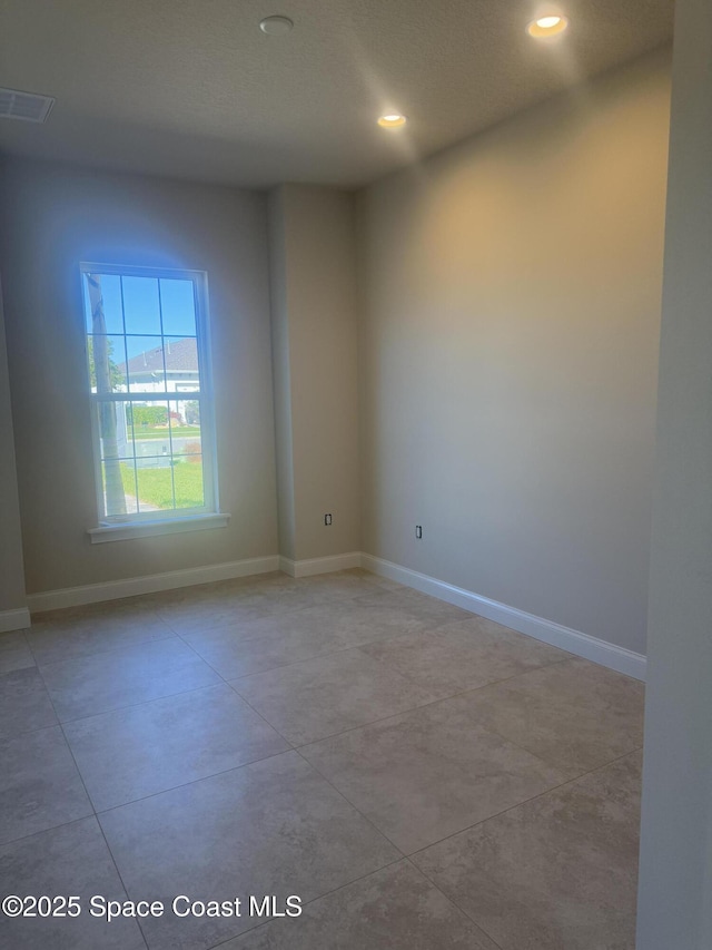 unfurnished room with light tile patterned floors, recessed lighting, visible vents, and baseboards