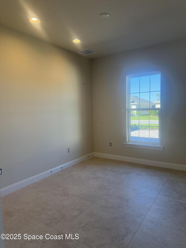 unfurnished room featuring recessed lighting, visible vents, and baseboards