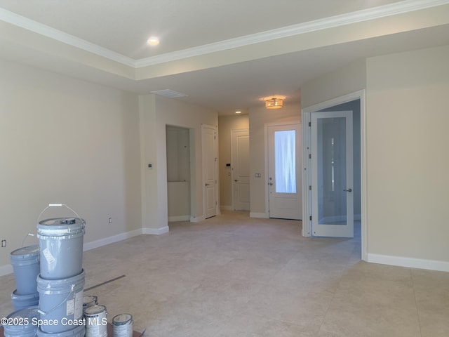 empty room featuring visible vents, crown molding, and baseboards