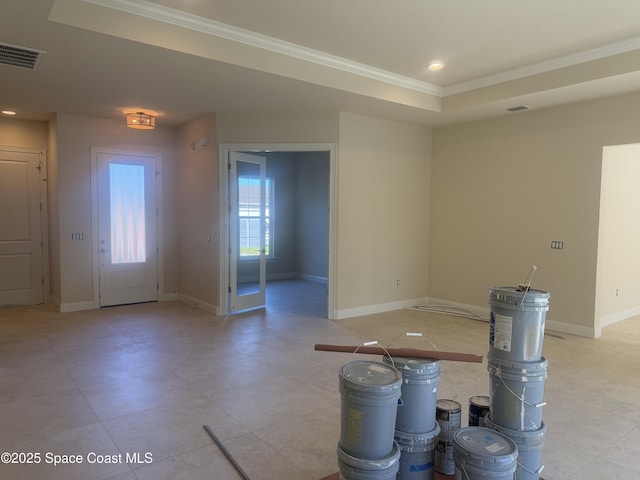 foyer featuring baseboards, visible vents, and crown molding