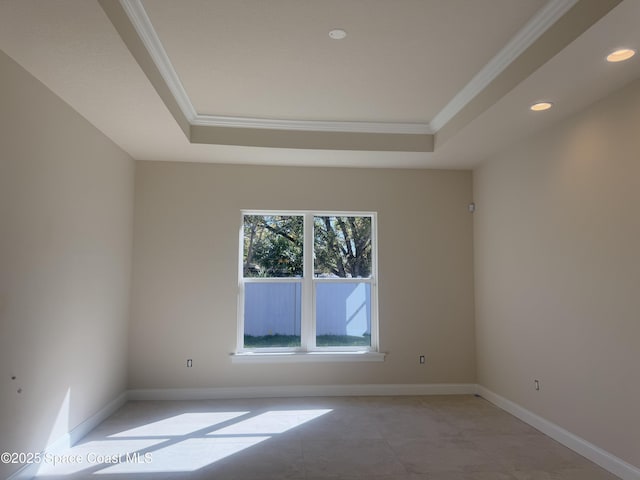 unfurnished room featuring ornamental molding, a tray ceiling, recessed lighting, and baseboards