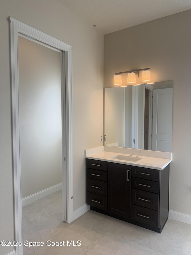 bathroom with tile patterned floors, vanity, and baseboards