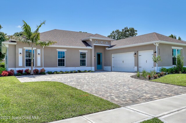 4335 Negal Cir, Melbourne, FL 32901 - single story home featuring a garage, stucco siding, decorative driveway, and a front yard