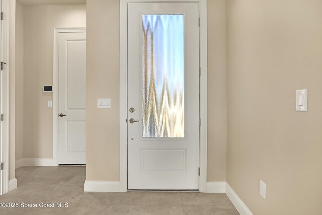 4335 Negal Cir, Melbourne, FL 32901 - doorway to outside featuring baseboards and light tile patterned floors