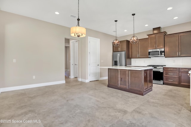 4335 Negal Cir, Melbourne, FL 32901 - kitchen with appliances with stainless steel finishes, a kitchen island, decorative backsplash, light countertops, and recessed lighting