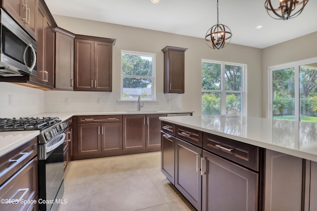 4335 Negal Cir, Melbourne, FL 32901 - kitchen featuring stainless steel appliances, a chandelier, a sink, decorative backsplash, and healthy amount of natural light