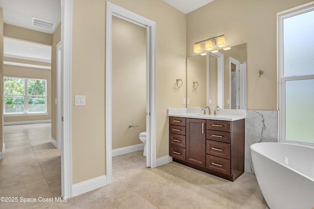 4335 Negal Cir, Melbourne, FL 32901 - bathroom with toilet, vanity, tile patterned floors, and a soaking tub