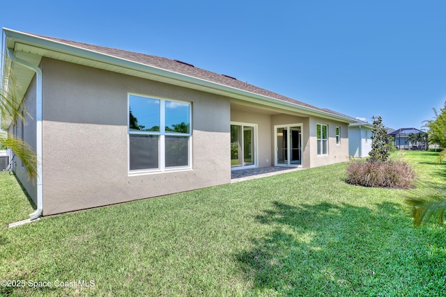 4335 Negal Cir, Melbourne, FL 32901 - rear view of house with stucco siding and a lawn
