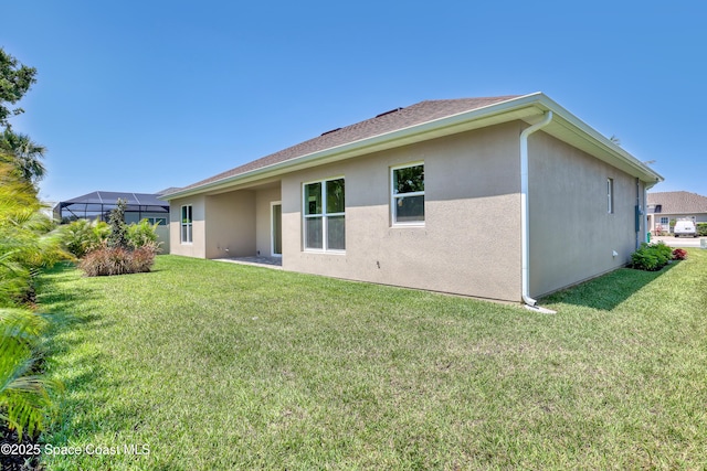 4335 Negal Cir, Melbourne, FL 32901 - rear view of property with stucco siding, a yard, and glass enclosure