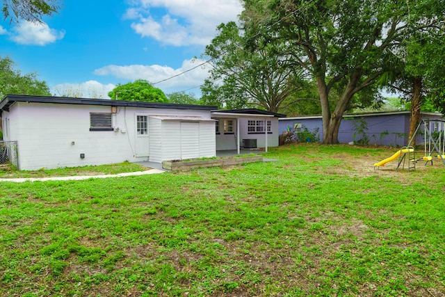 view of yard with a playground and central AC