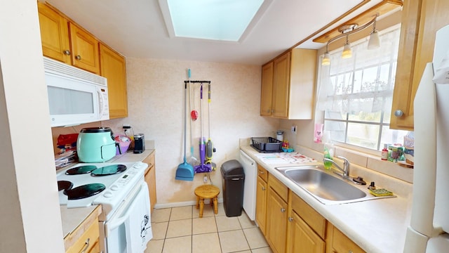 kitchen with white appliances, a skylight, sink, and light tile floors