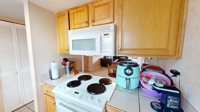 kitchen with light tile flooring and range