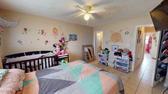 bedroom featuring a textured ceiling, ceiling fan, and light tile flooring