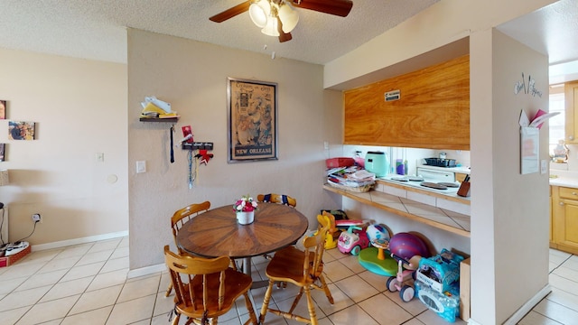 tiled dining room featuring a textured ceiling and ceiling fan