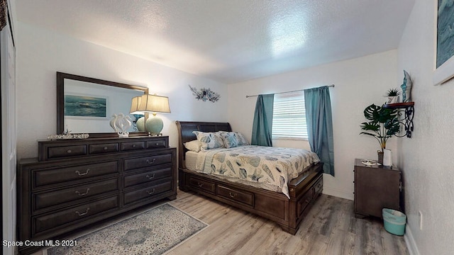 bedroom featuring a textured ceiling and light wood-type flooring