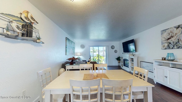 dining area featuring a textured ceiling and dark hardwood / wood-style flooring