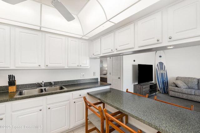 180 Flagler Ln Unit 22, Cocoa Beach, FL 32931 - kitchen with a sink, dark countertops, white cabinetry, a breakfast bar area, and open floor plan