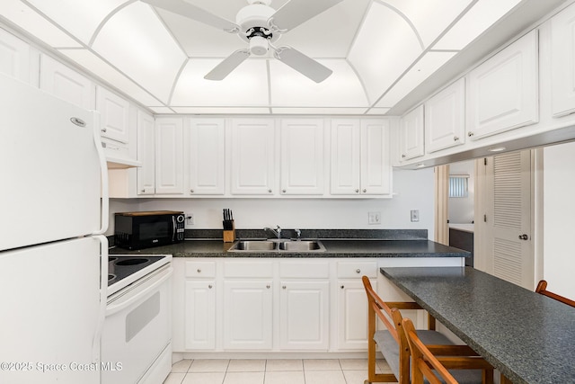 180 Flagler Ln Unit 22, Cocoa Beach, FL 32931 - kitchen featuring white appliances, a sink, white cabinetry, and dark countertops