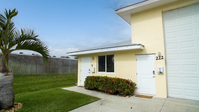 exterior space with a garage and a lawn