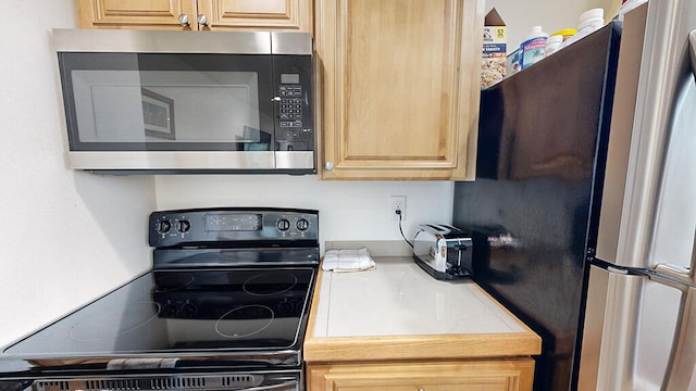 kitchen with light brown cabinets and appliances with stainless steel finishes