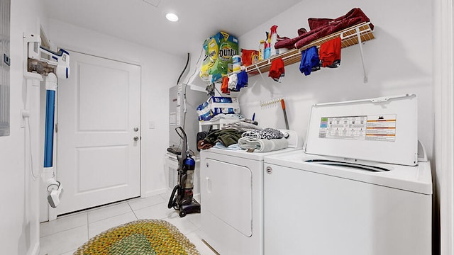 laundry room featuring washer and dryer and light tile flooring