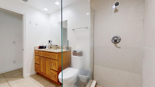 bathroom with tile floors, a tile shower, oversized vanity, and toilet