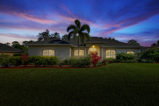 single story home featuring a lawn