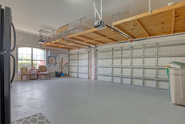 garage with black fridge and a garage door opener