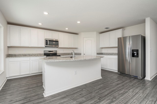 kitchen with white cabinets, an island with sink, stainless steel appliances, and dark hardwood / wood-style floors