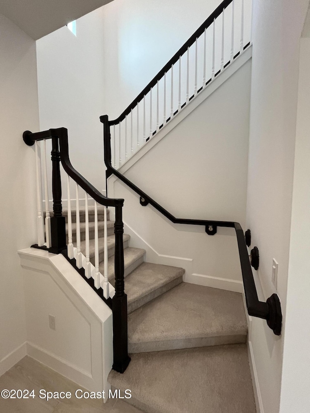 8526 Lyside Dr, Melbourne, FL 32940 - stairway featuring carpet flooring and baseboards
