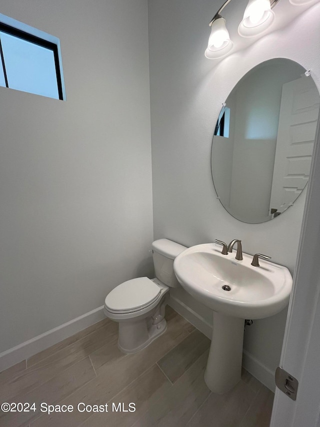 bathroom with wood-type flooring and toilet