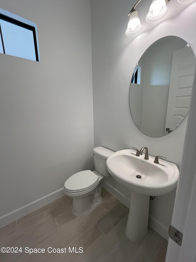 8526 Lyside Dr, Melbourne, FL 32940 - half bath featuring toilet, wood finished floors, and baseboards