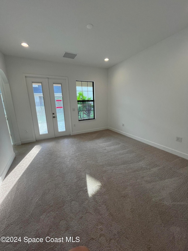 carpeted empty room featuring french doors