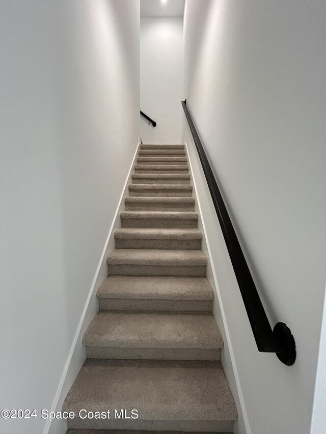 8526 Lyside Dr, Melbourne, FL 32940 - stairs featuring baseboards and carpet floors