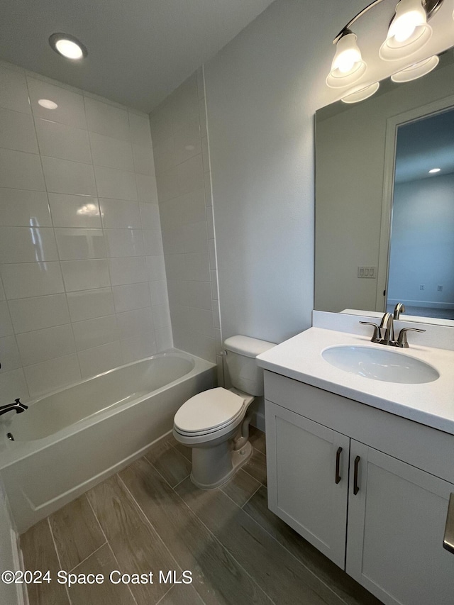 8526 Lyside Dr, Melbourne, FL 32940 - full bath featuring toilet, washtub / shower combination, wood finished floors, and vanity