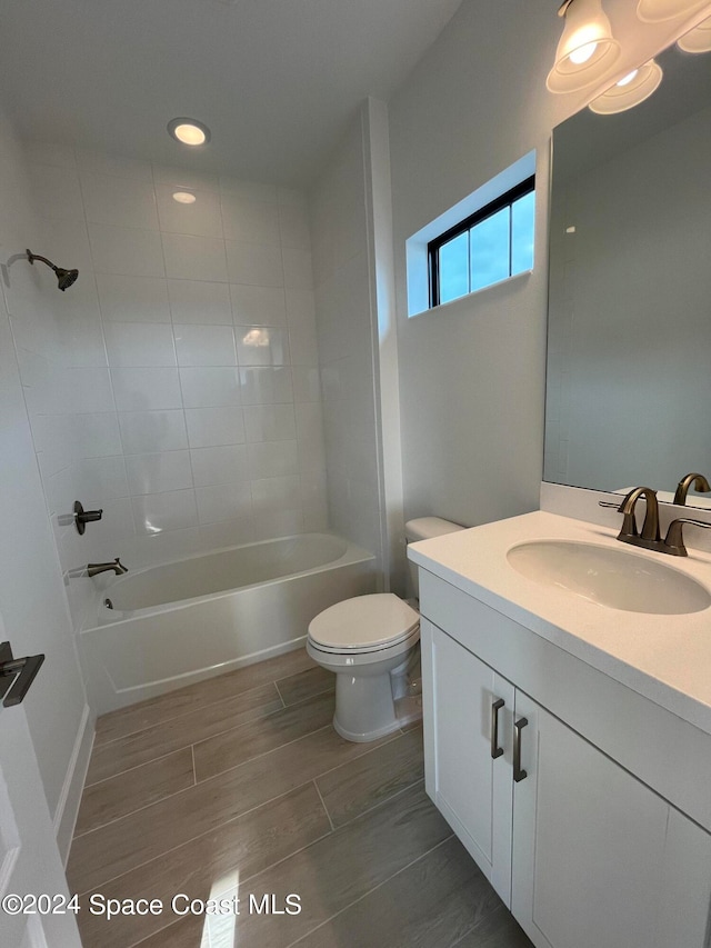 full bathroom with vanity, tiled shower / bath combo, and toilet