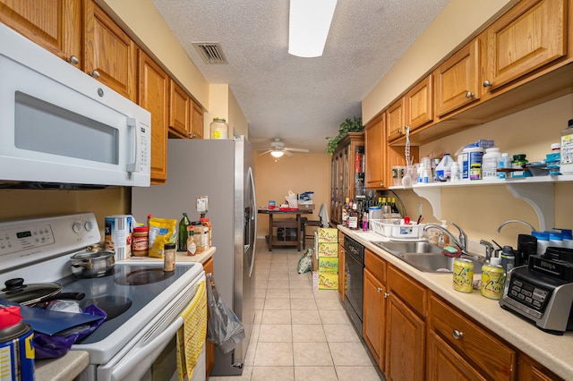 kitchen with ceiling fan, white appliances, sink, light tile floors, and a textured ceiling