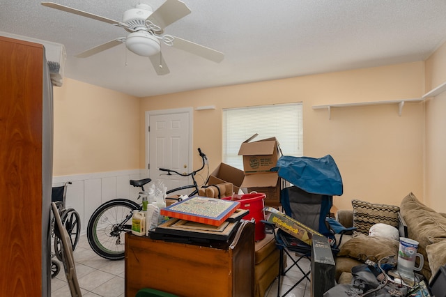 interior space with a textured ceiling and ceiling fan