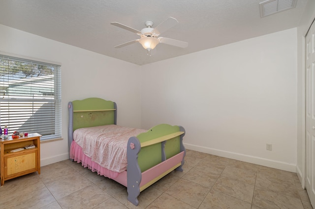 bedroom with ceiling fan and light tile floors