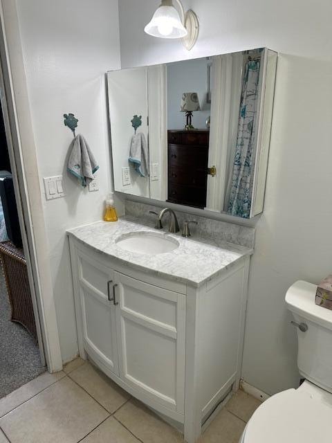 bathroom featuring tile floors, toilet, and vanity