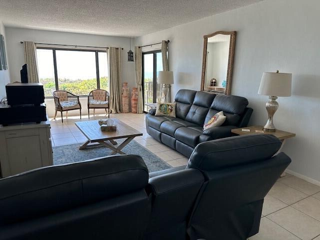 living room featuring a healthy amount of sunlight, a textured ceiling, and light tile flooring