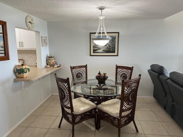 tiled dining room featuring a textured ceiling