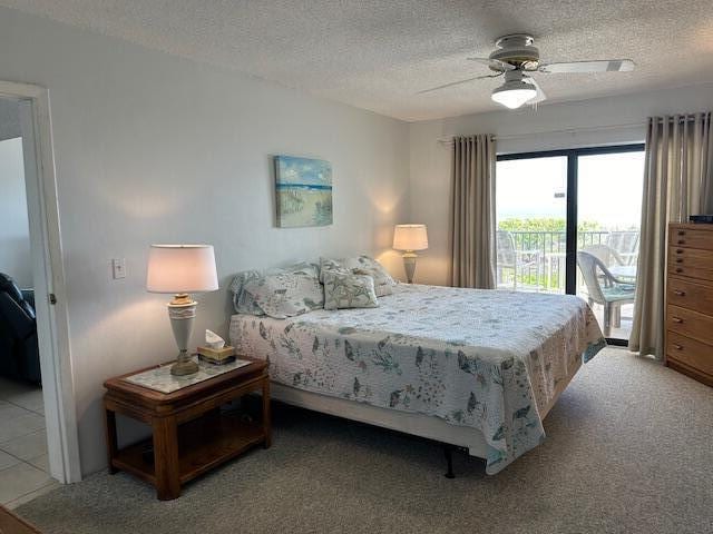 bedroom featuring a textured ceiling, ceiling fan, carpet floors, and access to outside