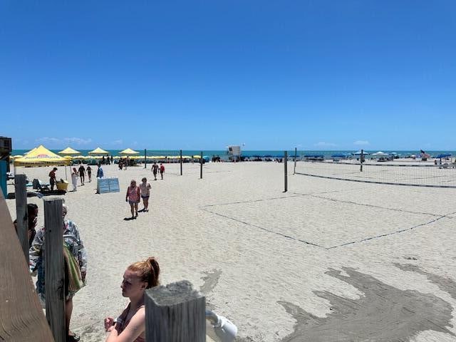 exterior space with a beach view, volleyball court, and a water view