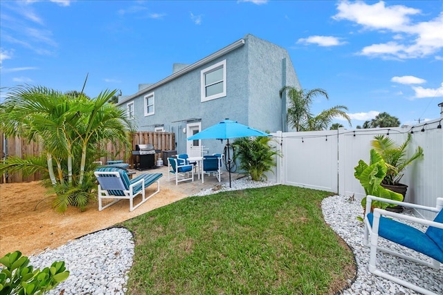 back of house featuring a yard and a patio