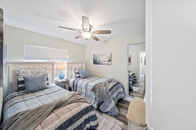 bedroom with a textured ceiling, hardwood / wood-style flooring, and ceiling fan