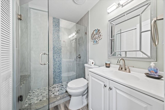 bathroom with hardwood / wood-style flooring, vanity, toilet, and walk in shower